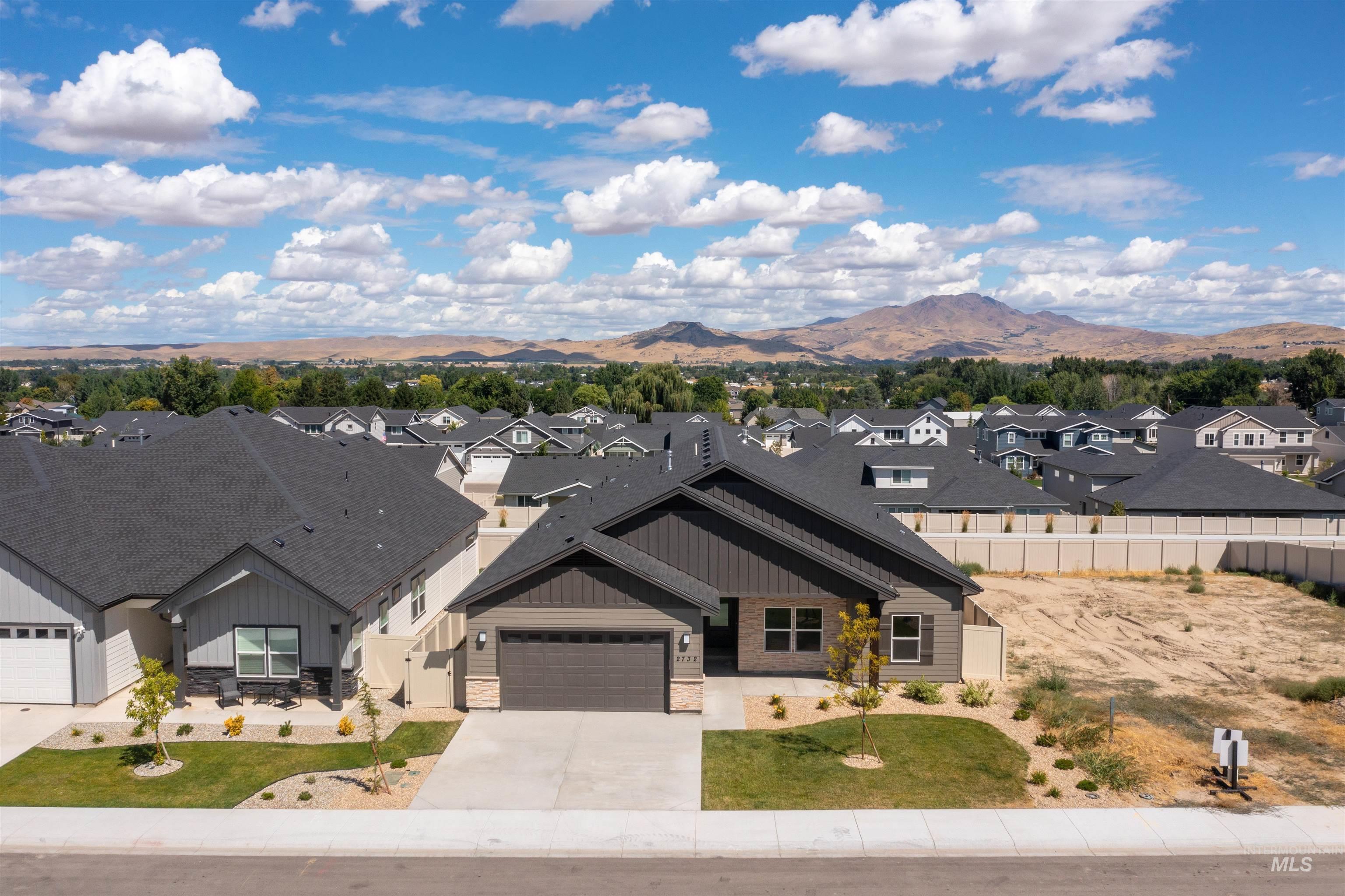 Craftsman inspired home with board and batten siding, a residential view, a mountain view, and driveway