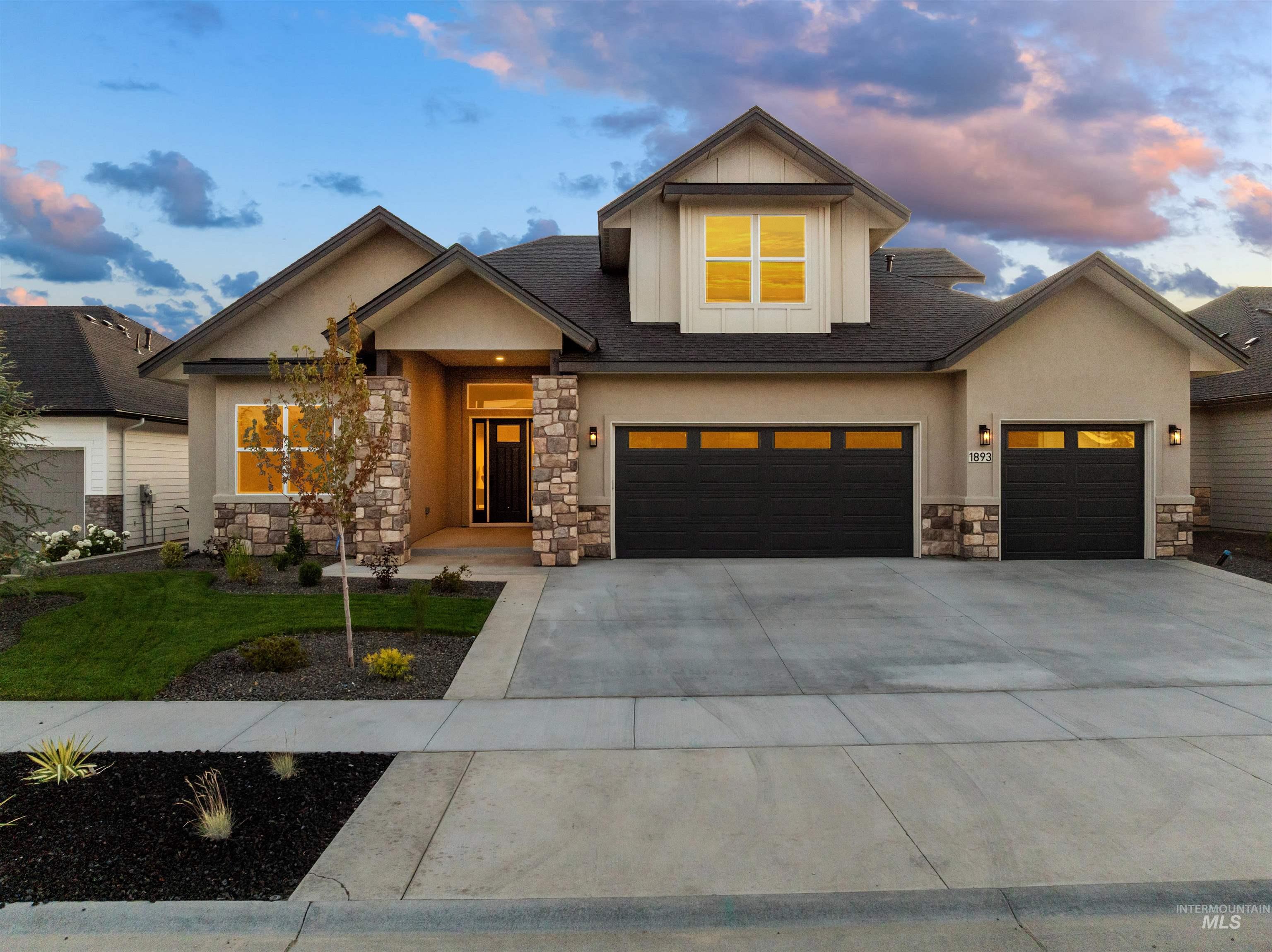 View of front of property with stone siding, driveway, stucco siding, a garage, and a front lawn