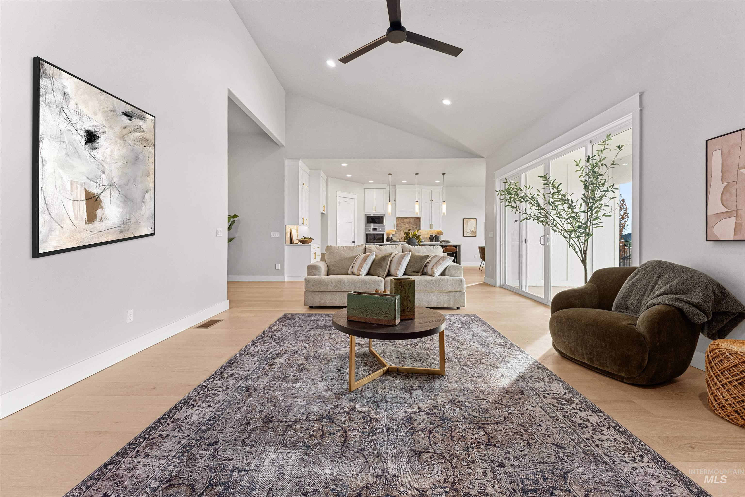 Living room with a ceiling fan, light wood-type flooring, recessed lighting, and high vaulted ceiling