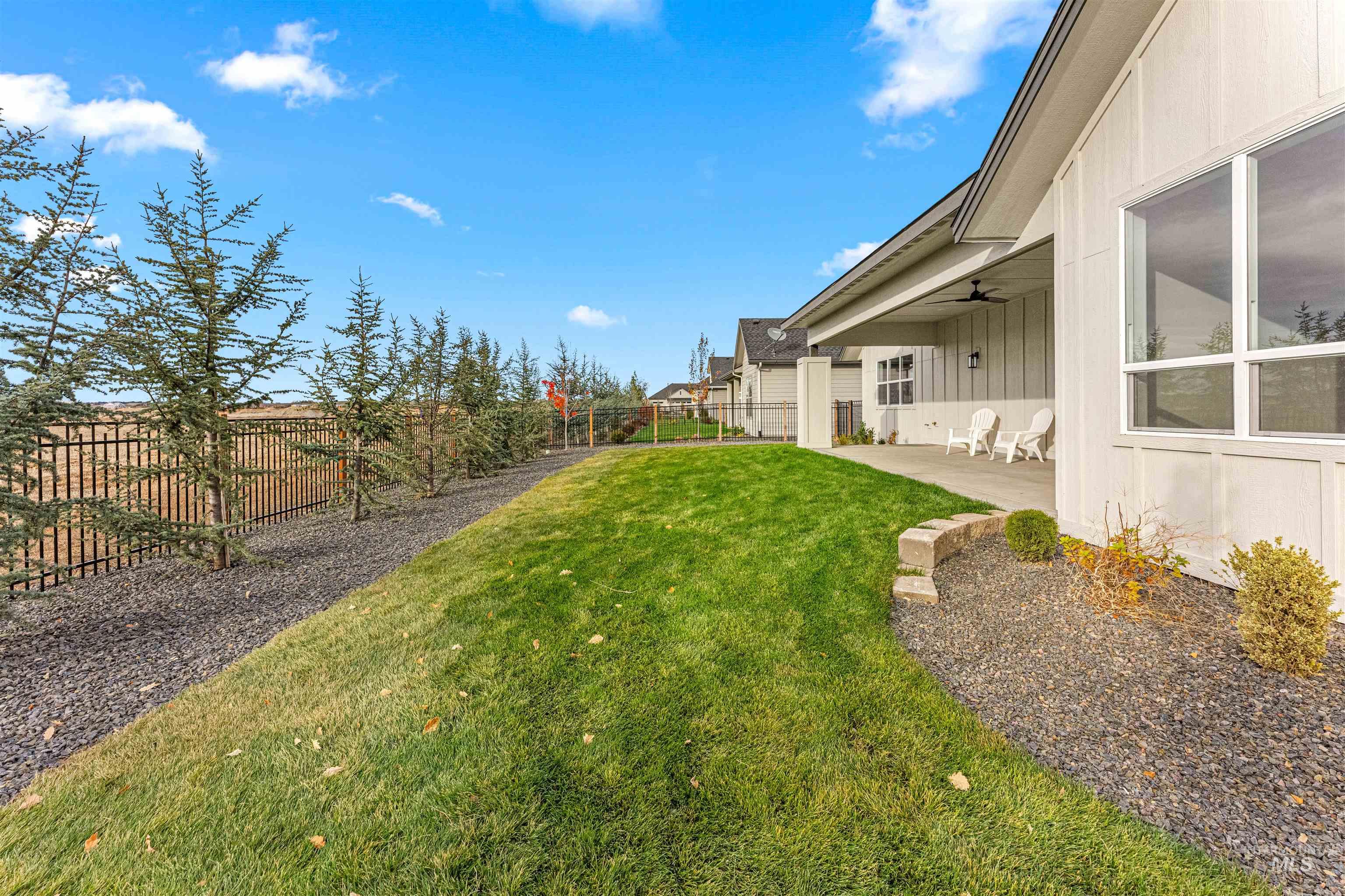 Fenced backyard with a patio area and ceiling fan