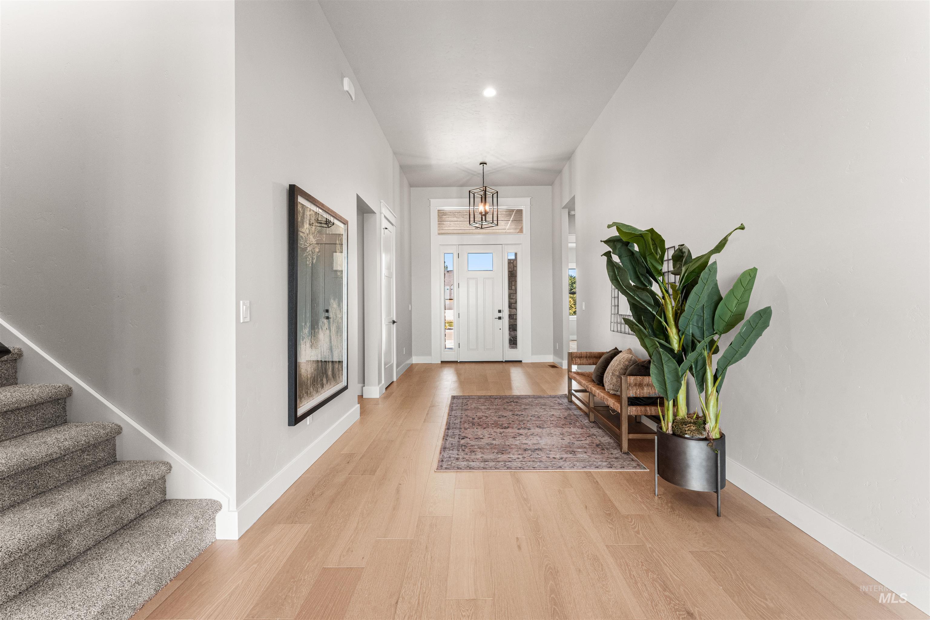 Entryway with light wood-type flooring, stairs, a chandelier, and recessed lighting