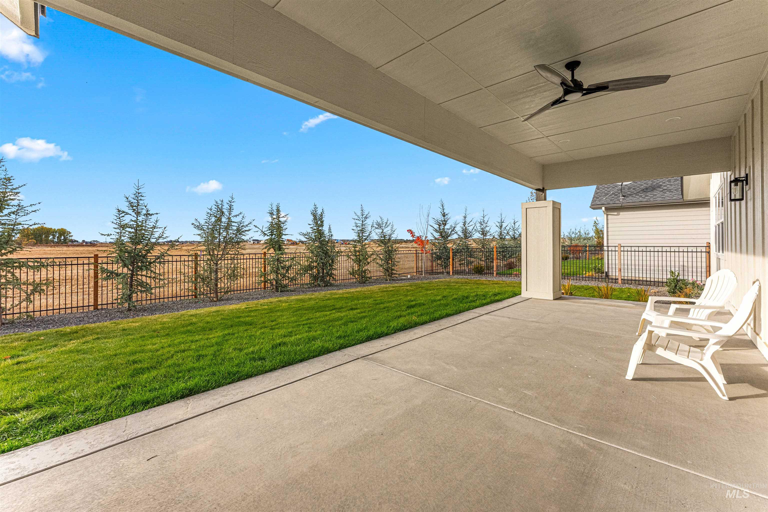 Fenced backyard featuring a patio area and a ceiling fan