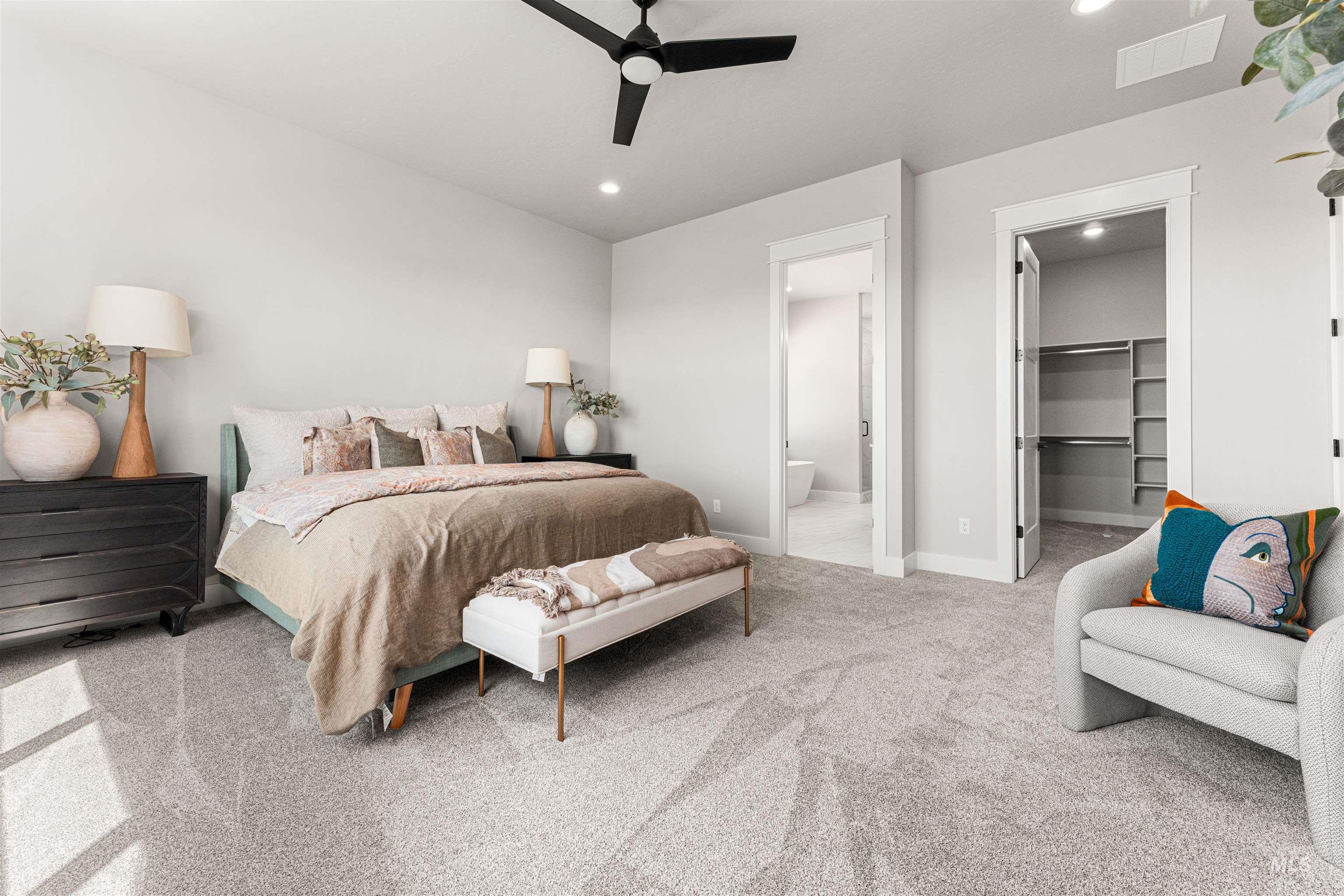 Carpeted bedroom with recessed lighting, a spacious closet, ensuite bathroom, and ceiling fan