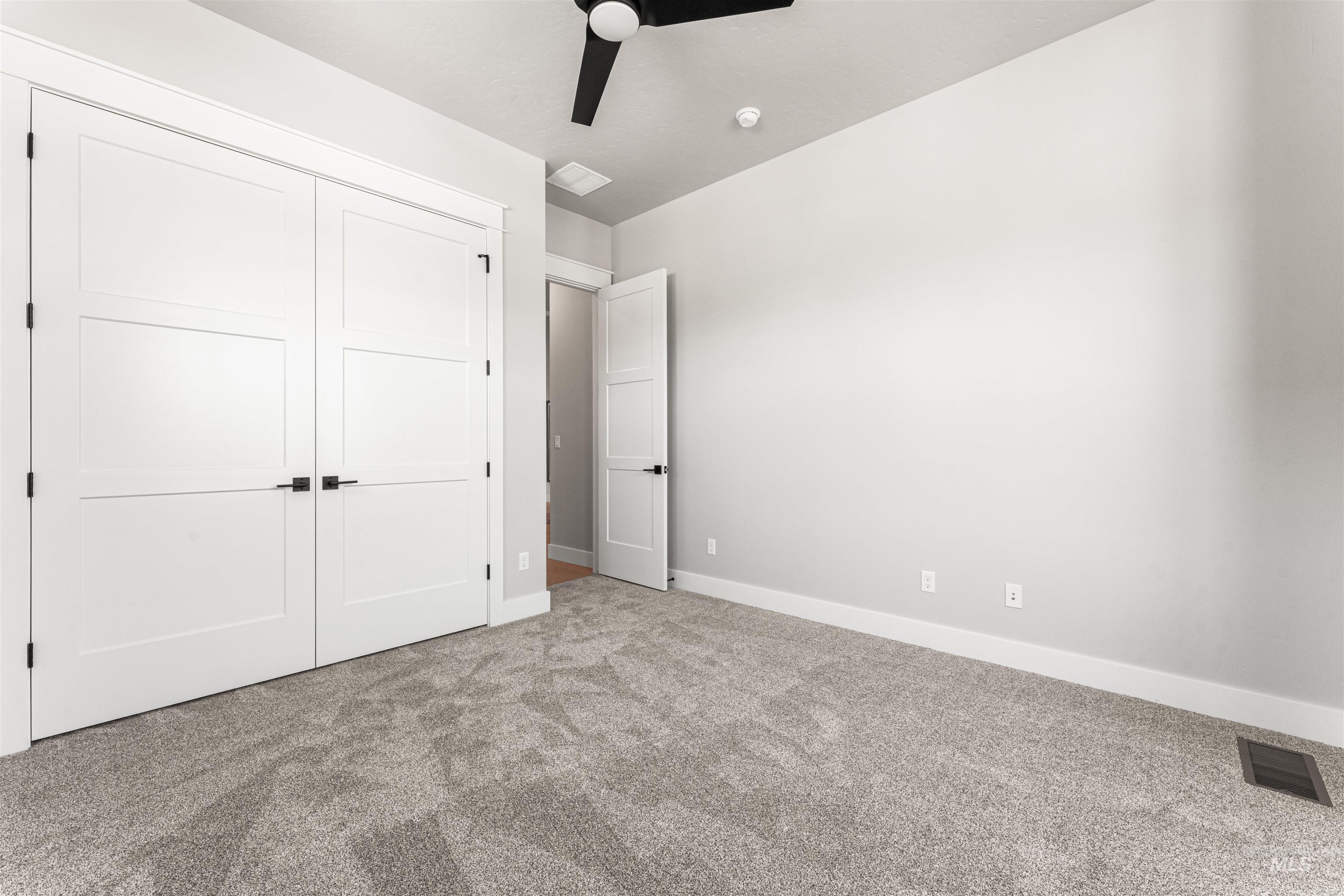 Unfurnished bedroom featuring carpet, a closet, and ceiling fan
