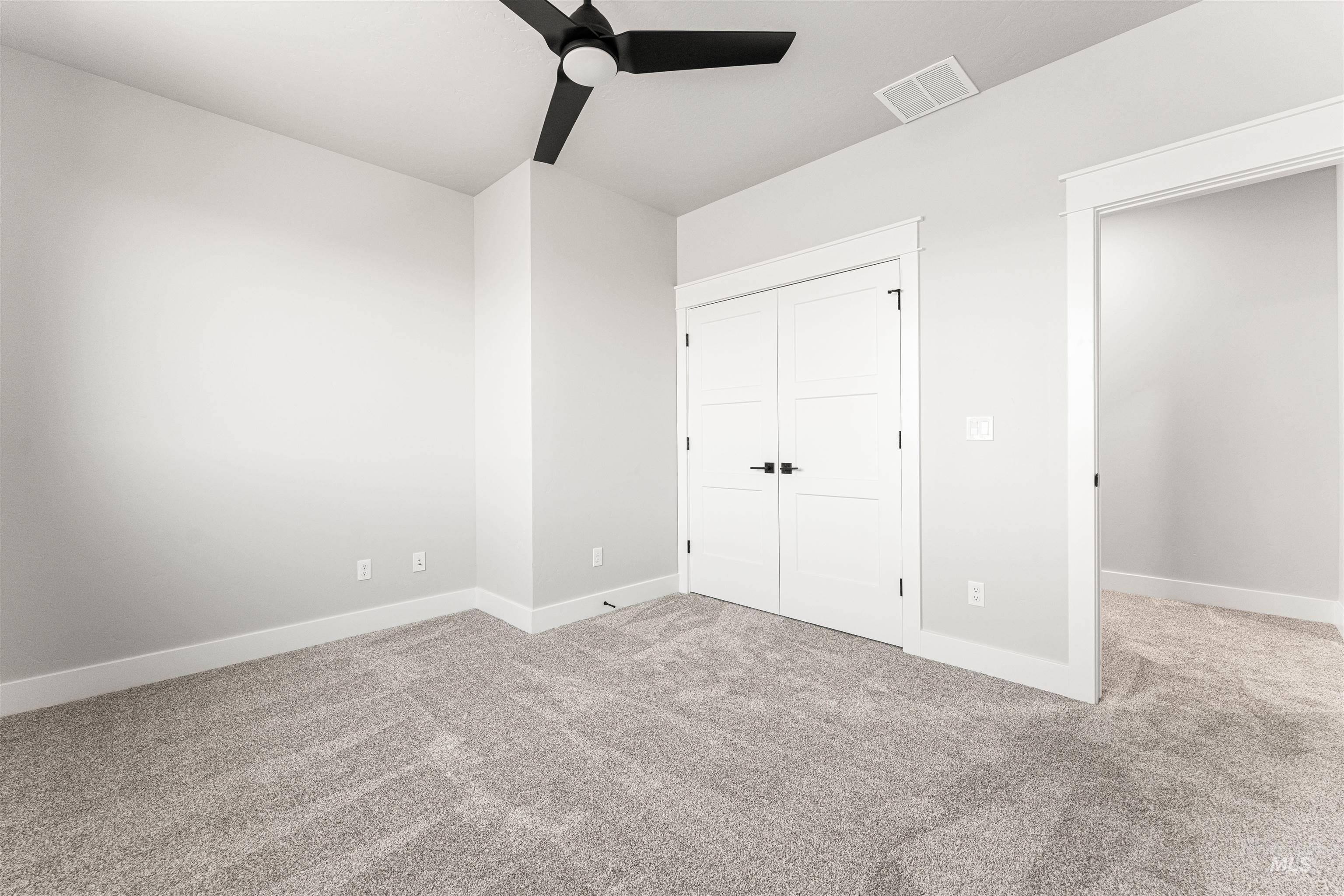 Unfurnished bedroom featuring carpet, a closet, ceiling fan, and vaulted ceiling