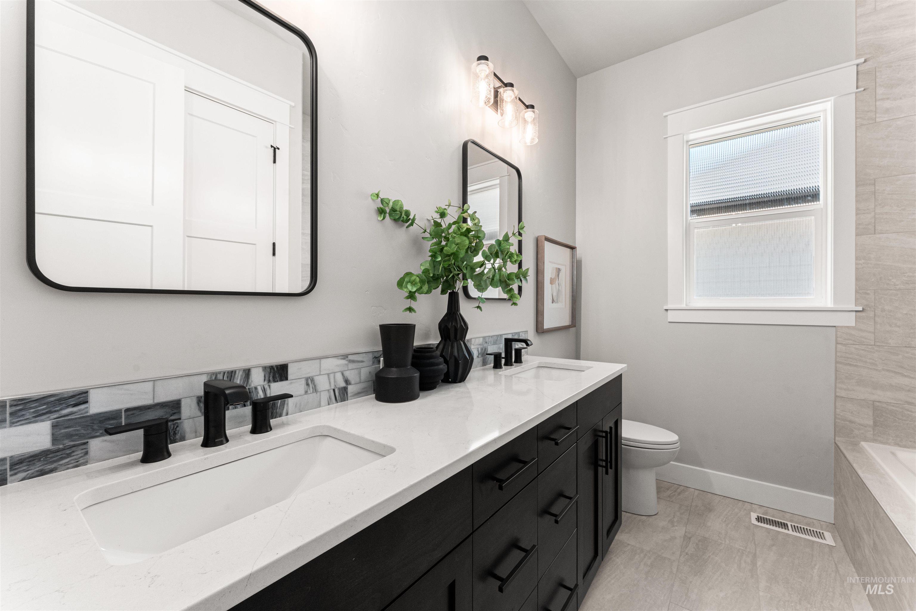 Bathroom featuring double vanity and tiled tub