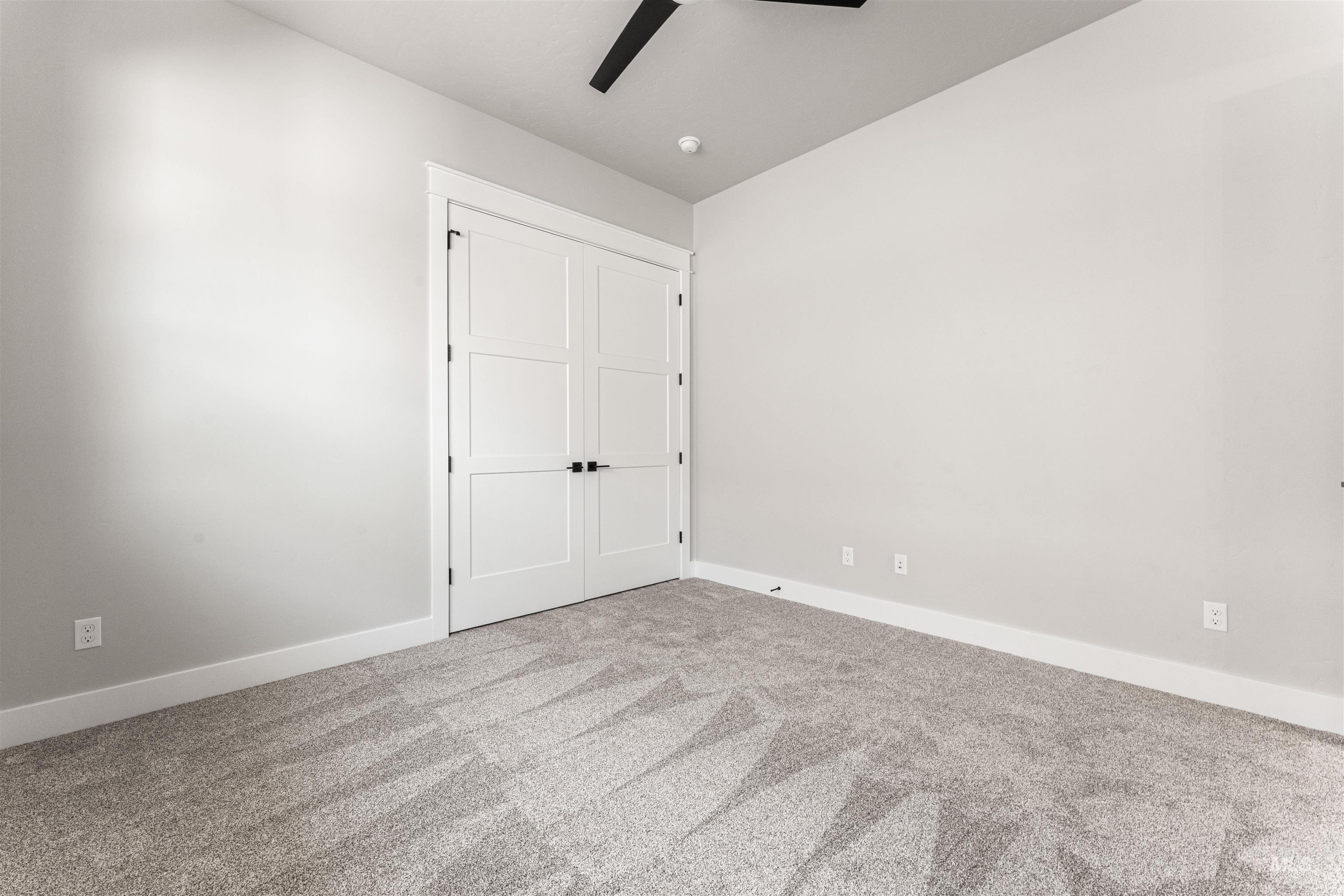 Unfurnished bedroom with carpet flooring and a ceiling fan