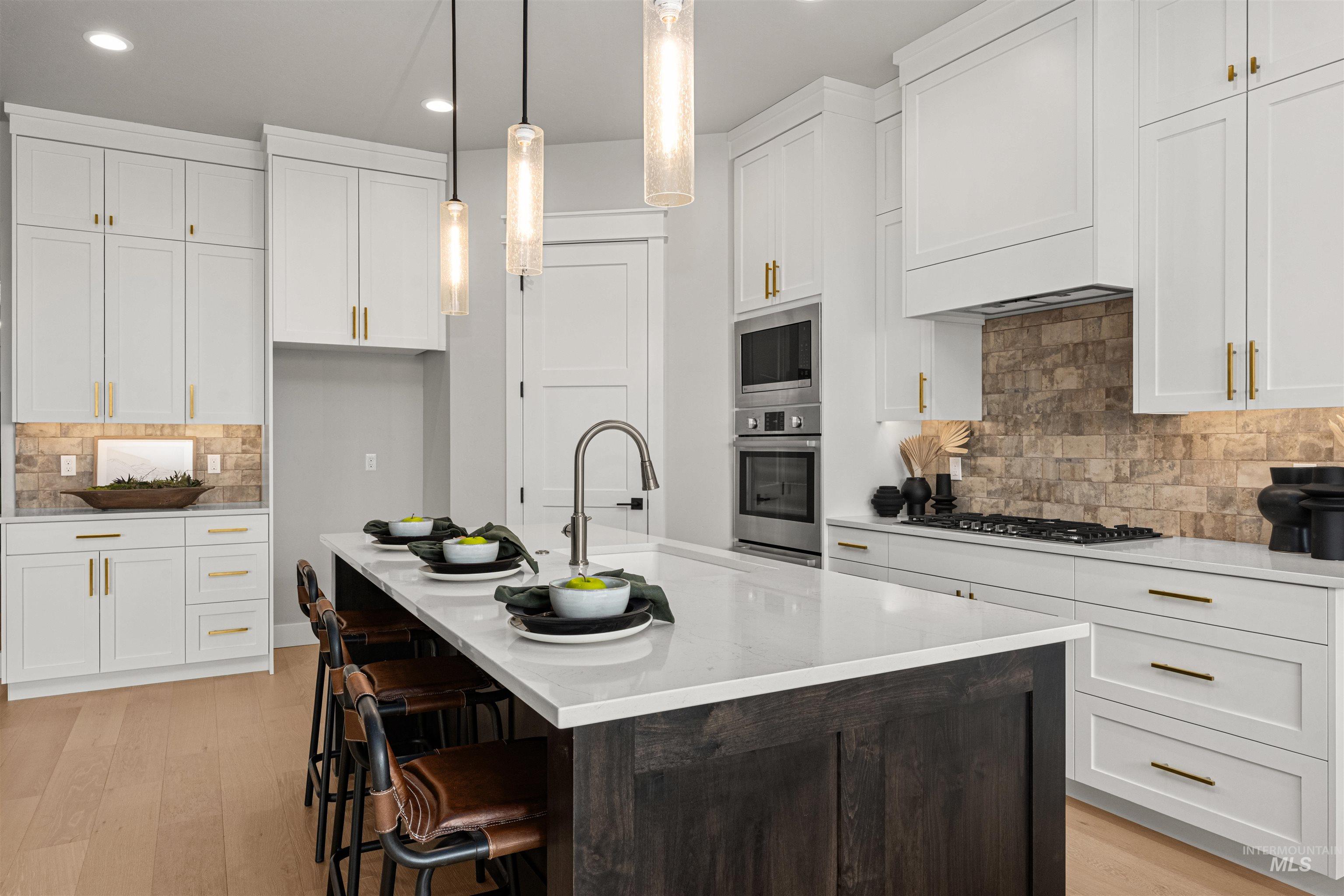 Kitchen featuring decorative backsplash, light wood finished floors, white cabinets, pendant lighting, and recessed lighting