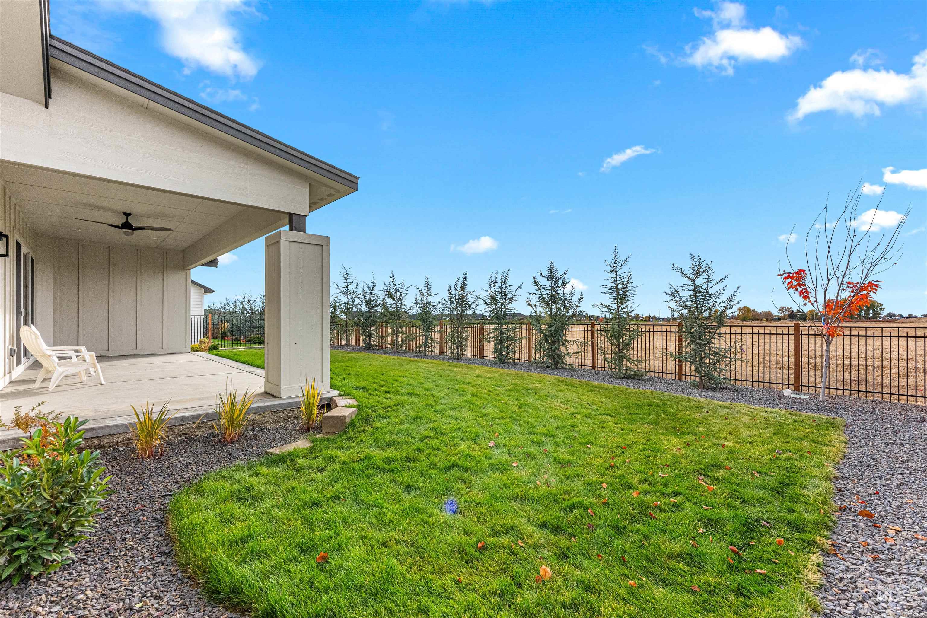 Fenced backyard featuring a ceiling fan and a patio