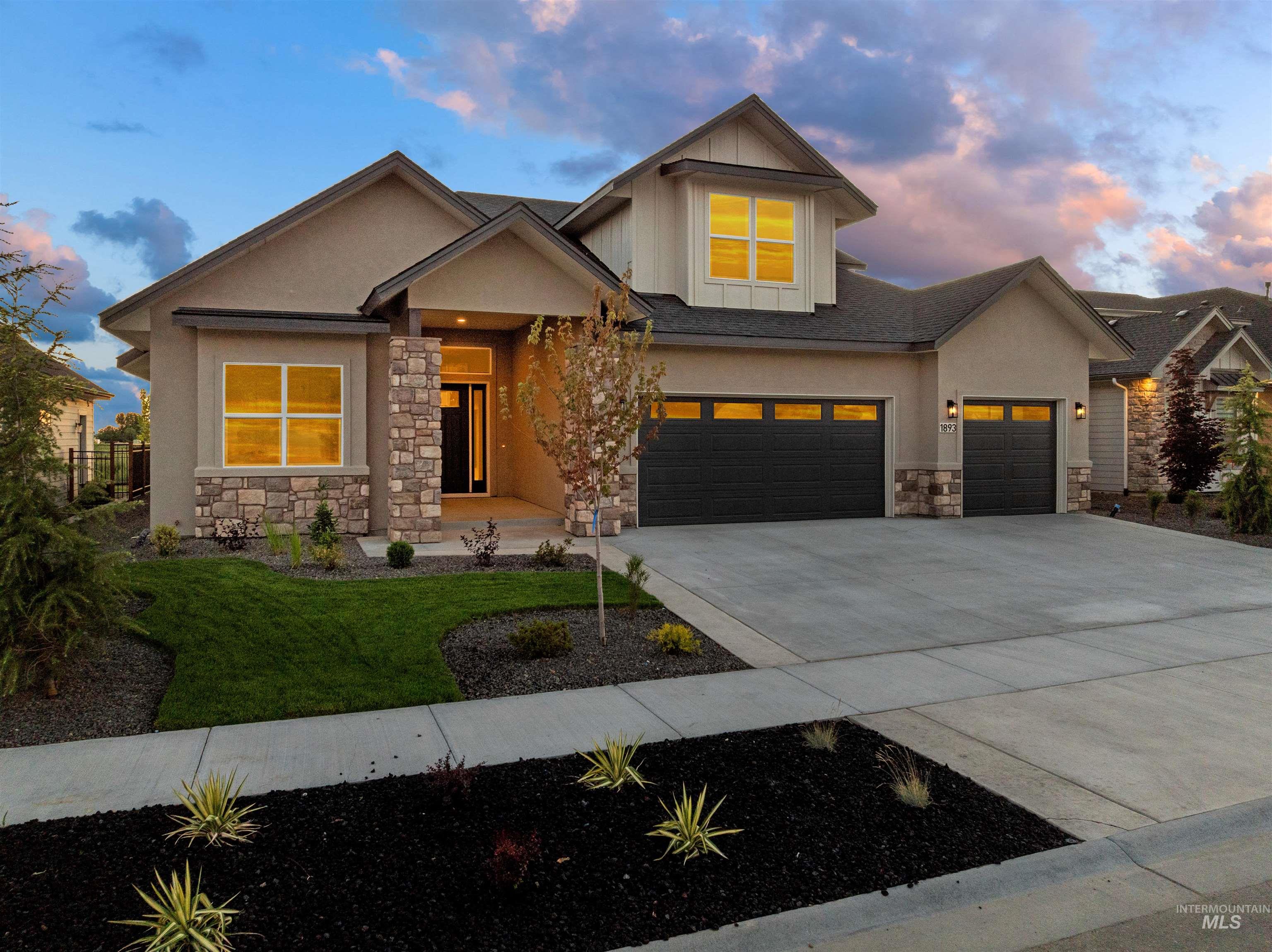 View of front of house with stone siding, concrete driveway, stucco siding, and a garage