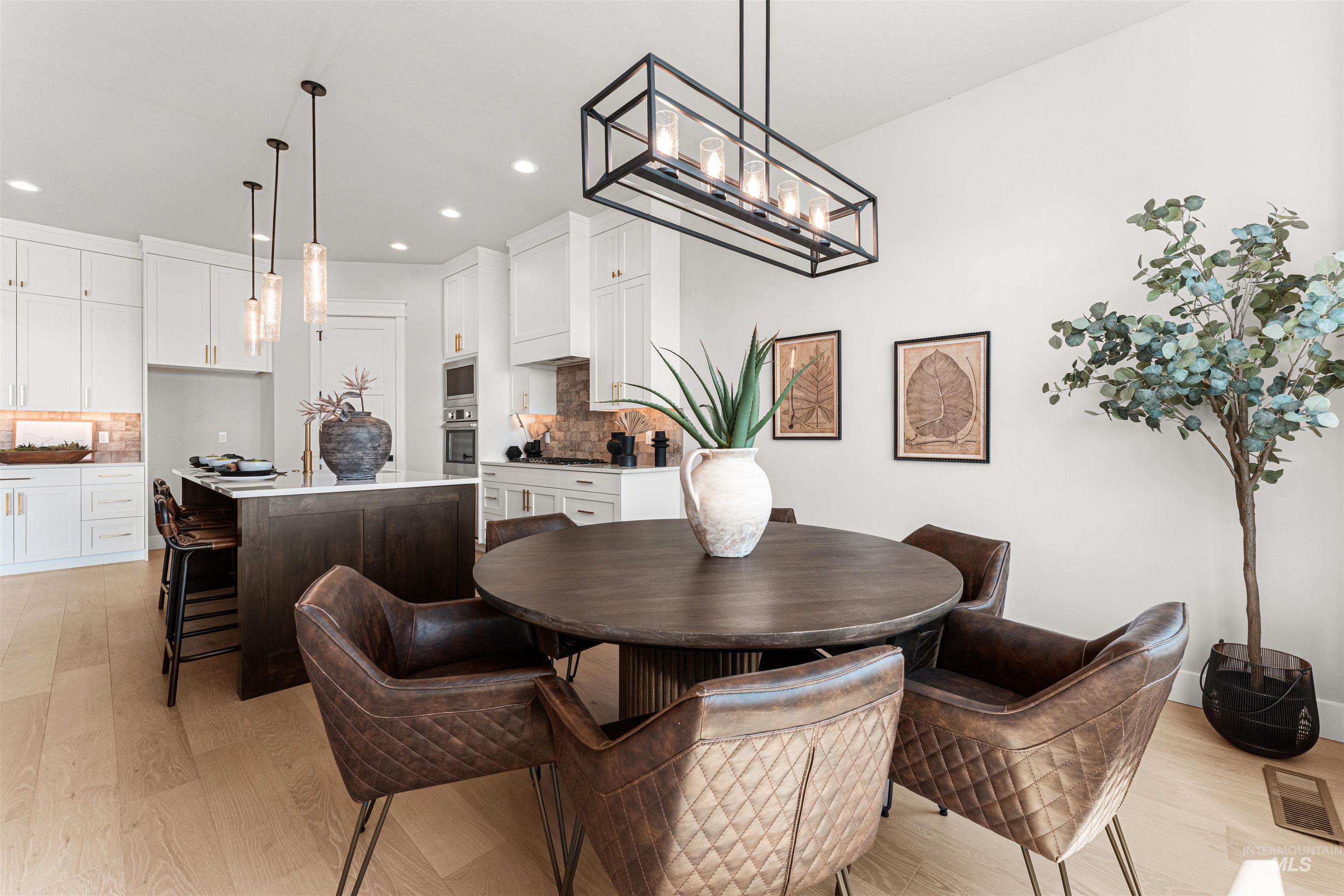 Dining area with light wood-style floors and recessed lighting