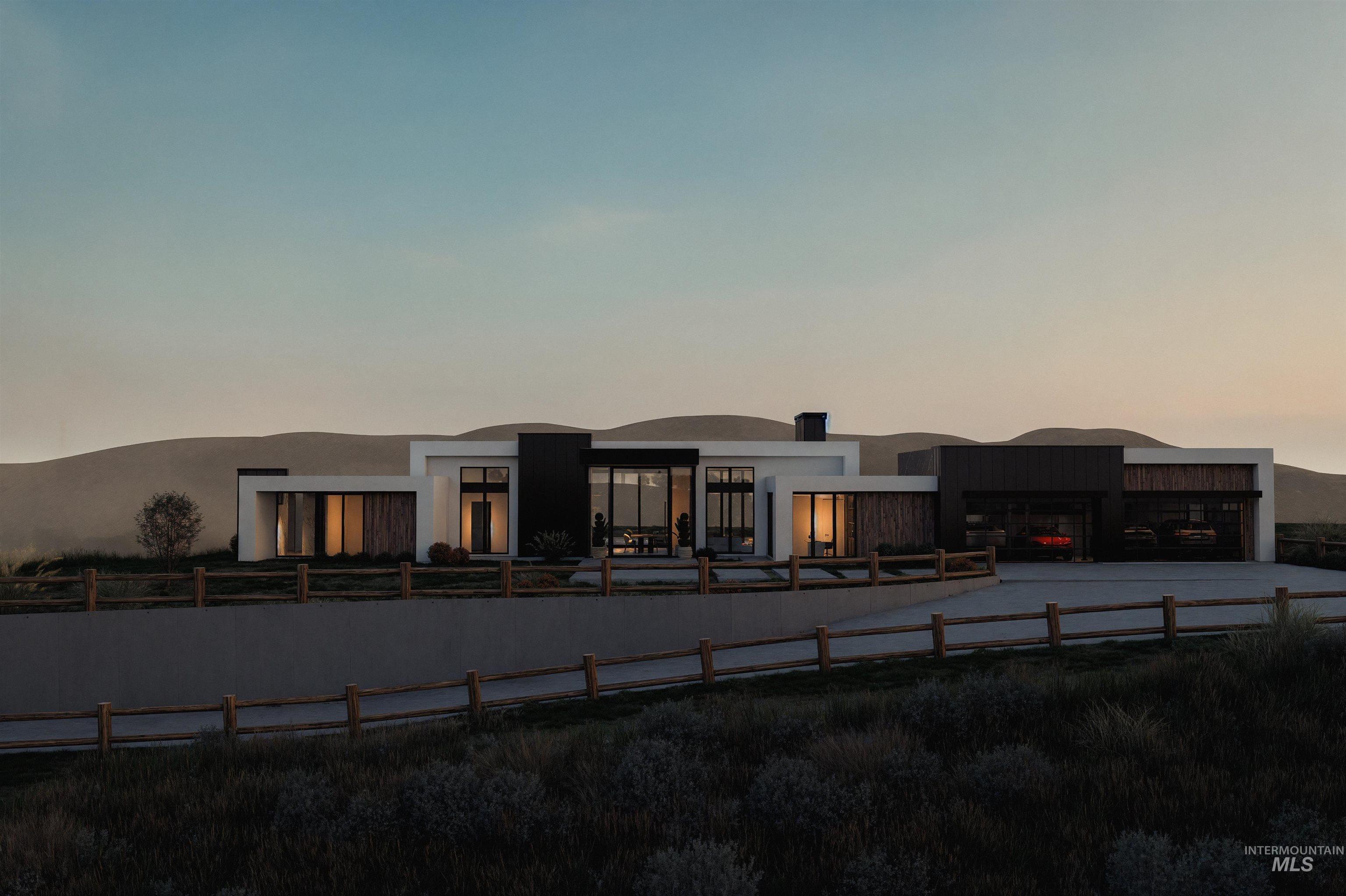 Back of house at dusk featuring stucco siding, an attached garage, and driveway
