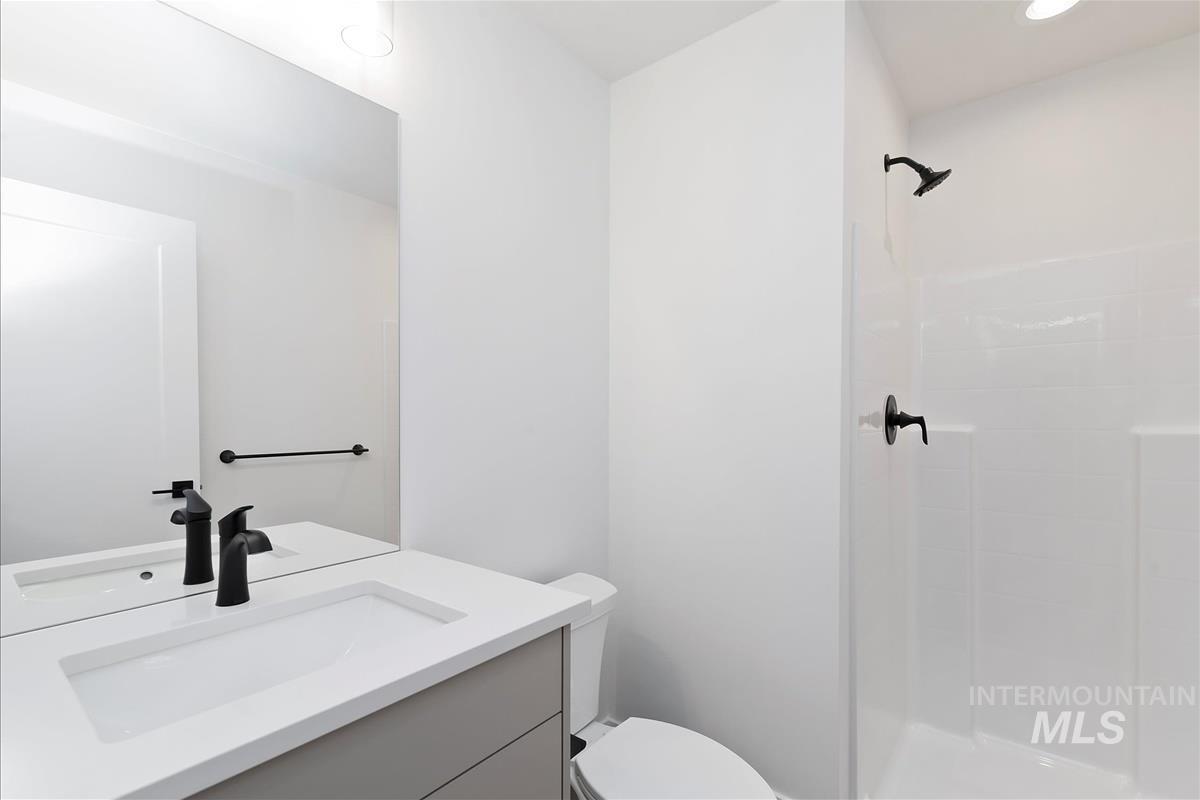 Full bathroom featuring vanity, a shower stall, and recessed lighting
