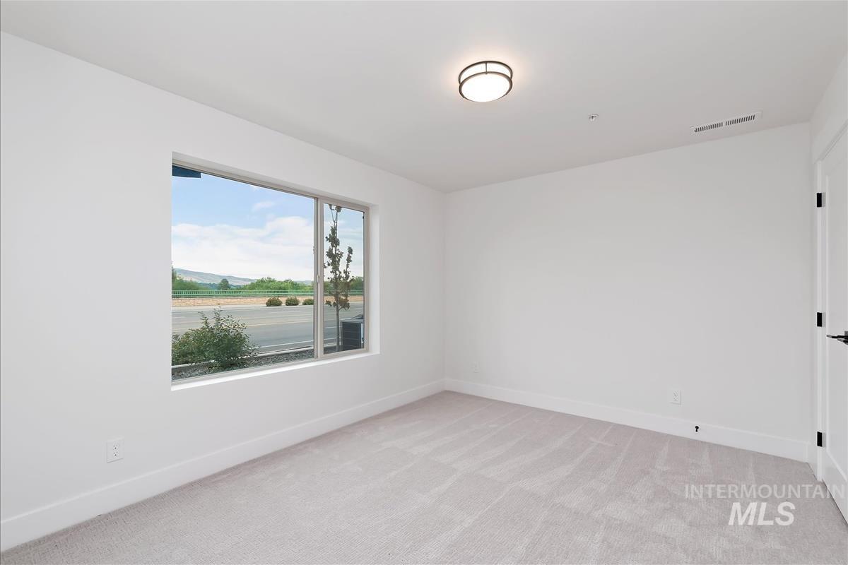Spare room with light colored carpet and baseboards