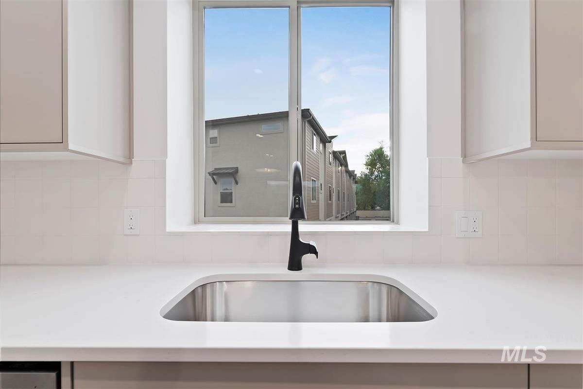 Kitchen with light stone countertops and decorative backsplash