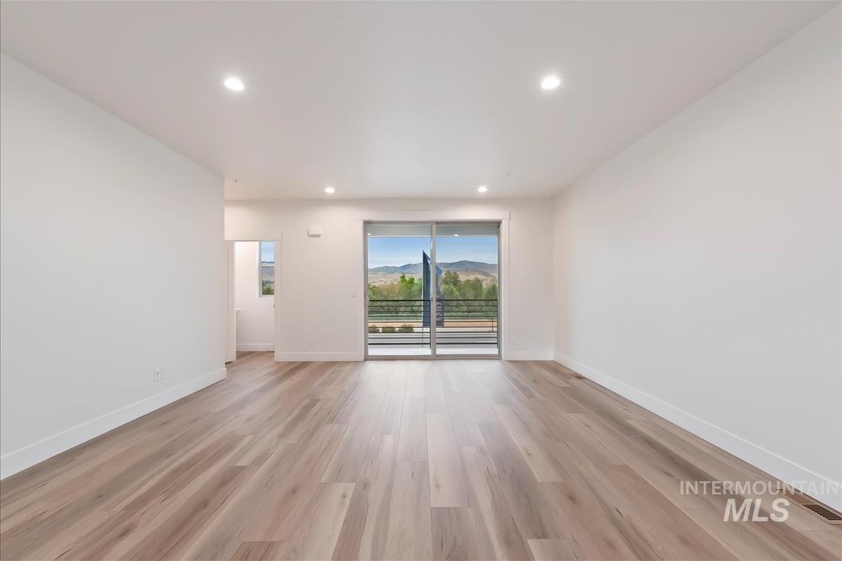 Unfurnished room featuring recessed lighting, light wood-style floors, and a mountain view