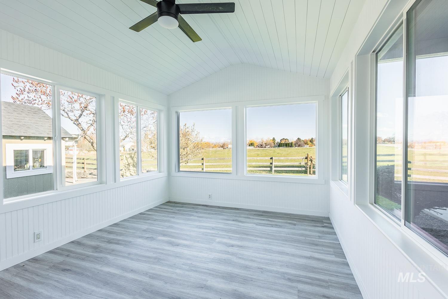 Unfurnished sunroom with plenty of natural light, wood finished floors, lofted ceiling, and wooden ceiling