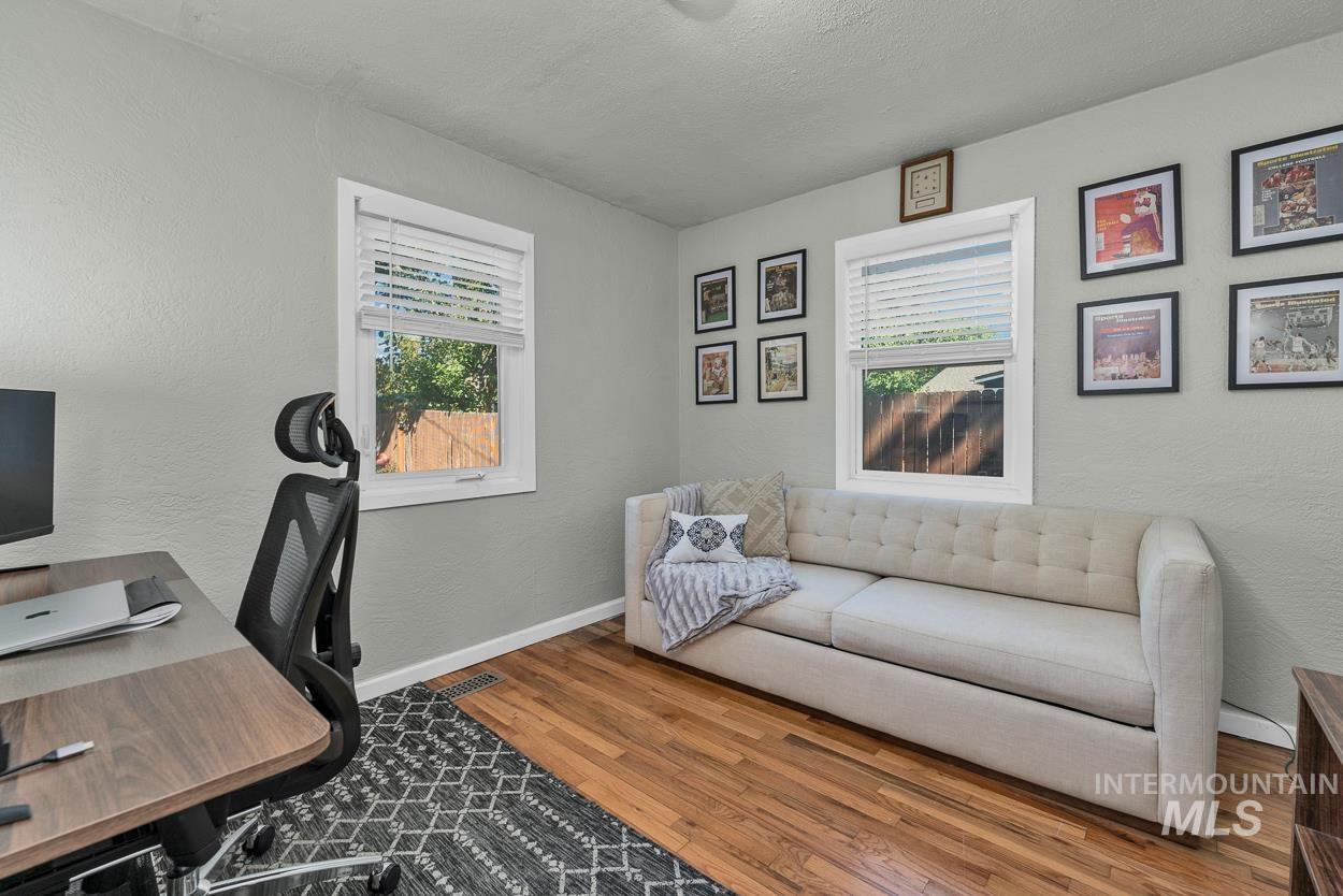 Office area featuring a textured wall, wood finished floors, and a textured ceiling