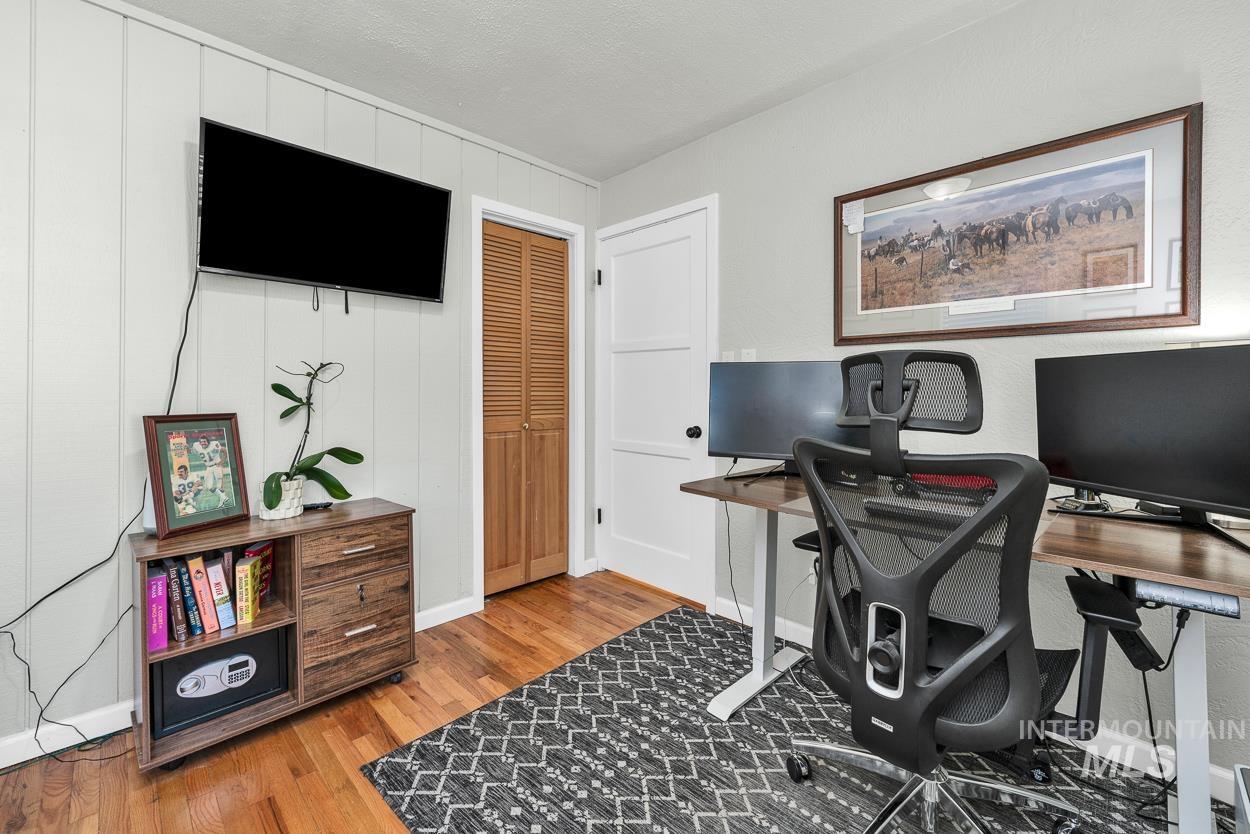 Office featuring light wood-type flooring and a textured ceiling