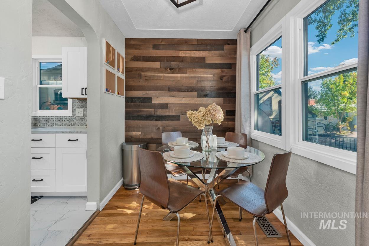 Dining room with wooden walls and light wood-style flooring