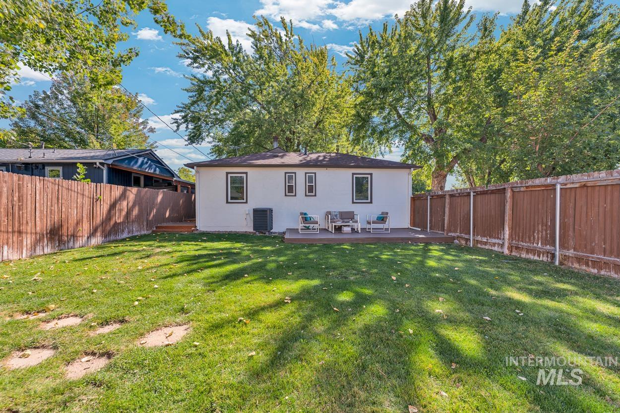 Back of property featuring a fenced backyard, a deck, and stucco siding