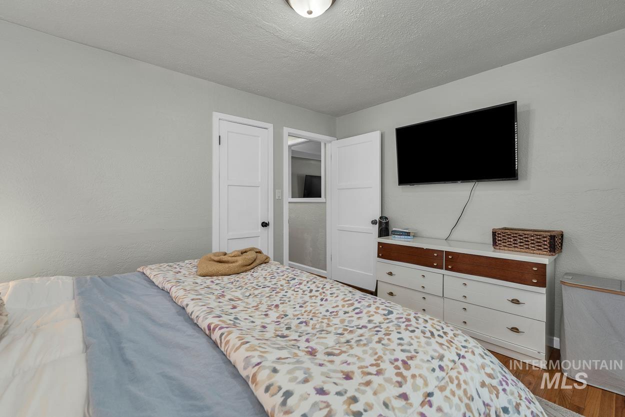 Bedroom with a textured ceiling and dark wood-style flooring