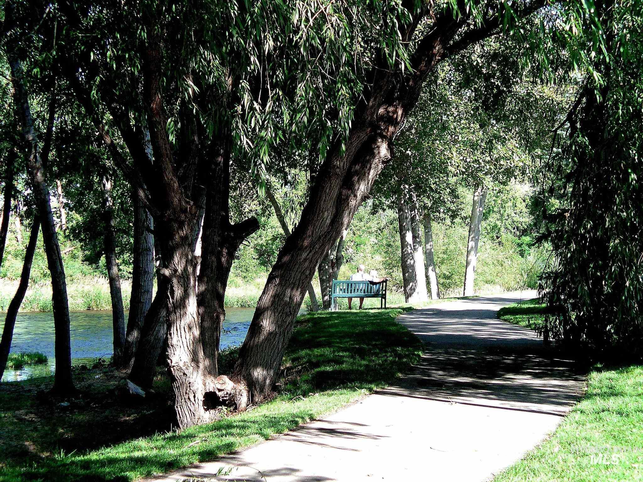 View of property's community featuring a lawn and a water view