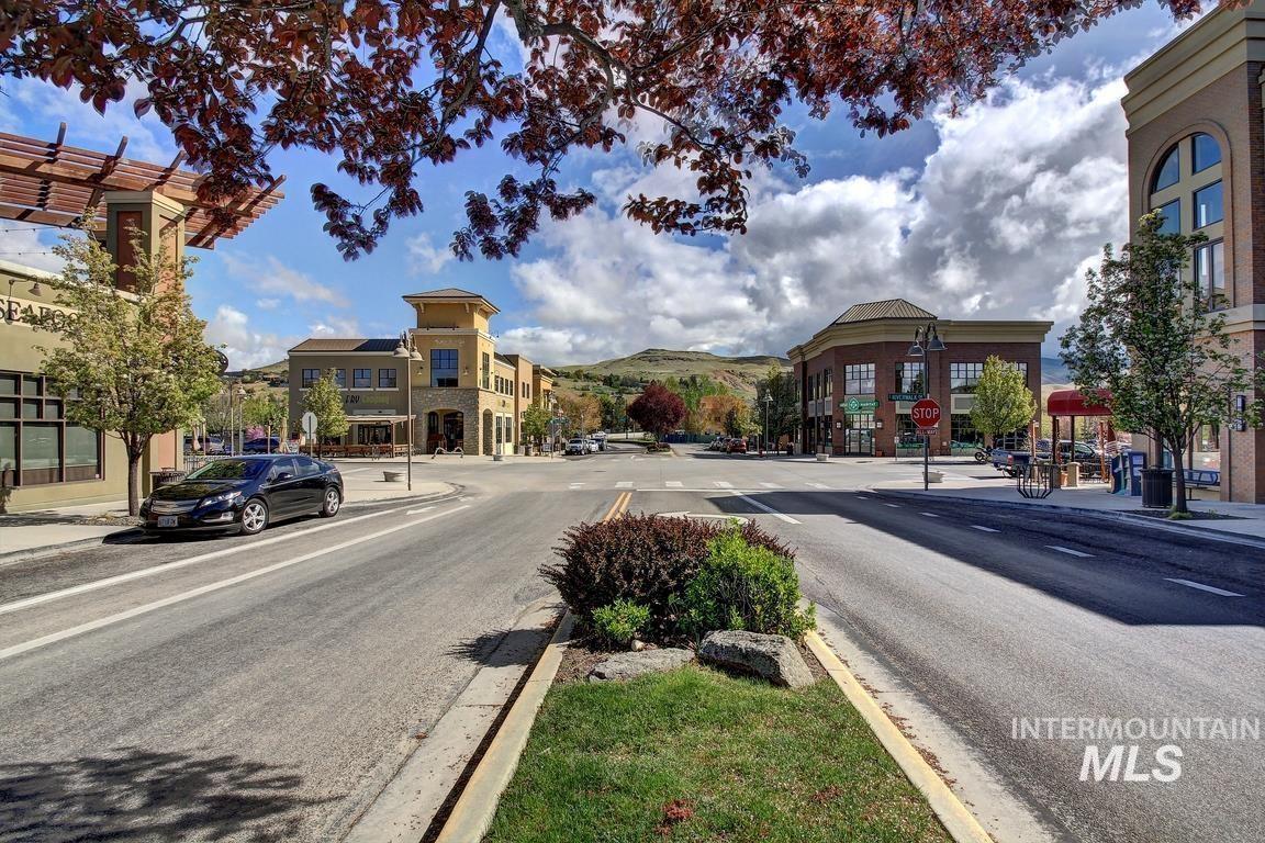 View of asphalt road with curbs, sidewalks, and street lights