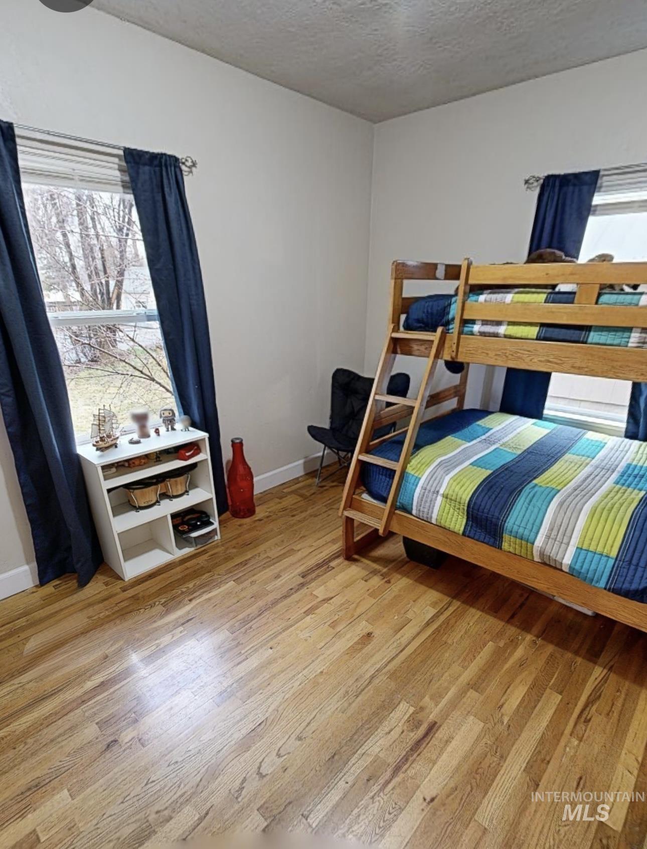 Bedroom featuring light wood-style floors and a textured ceiling