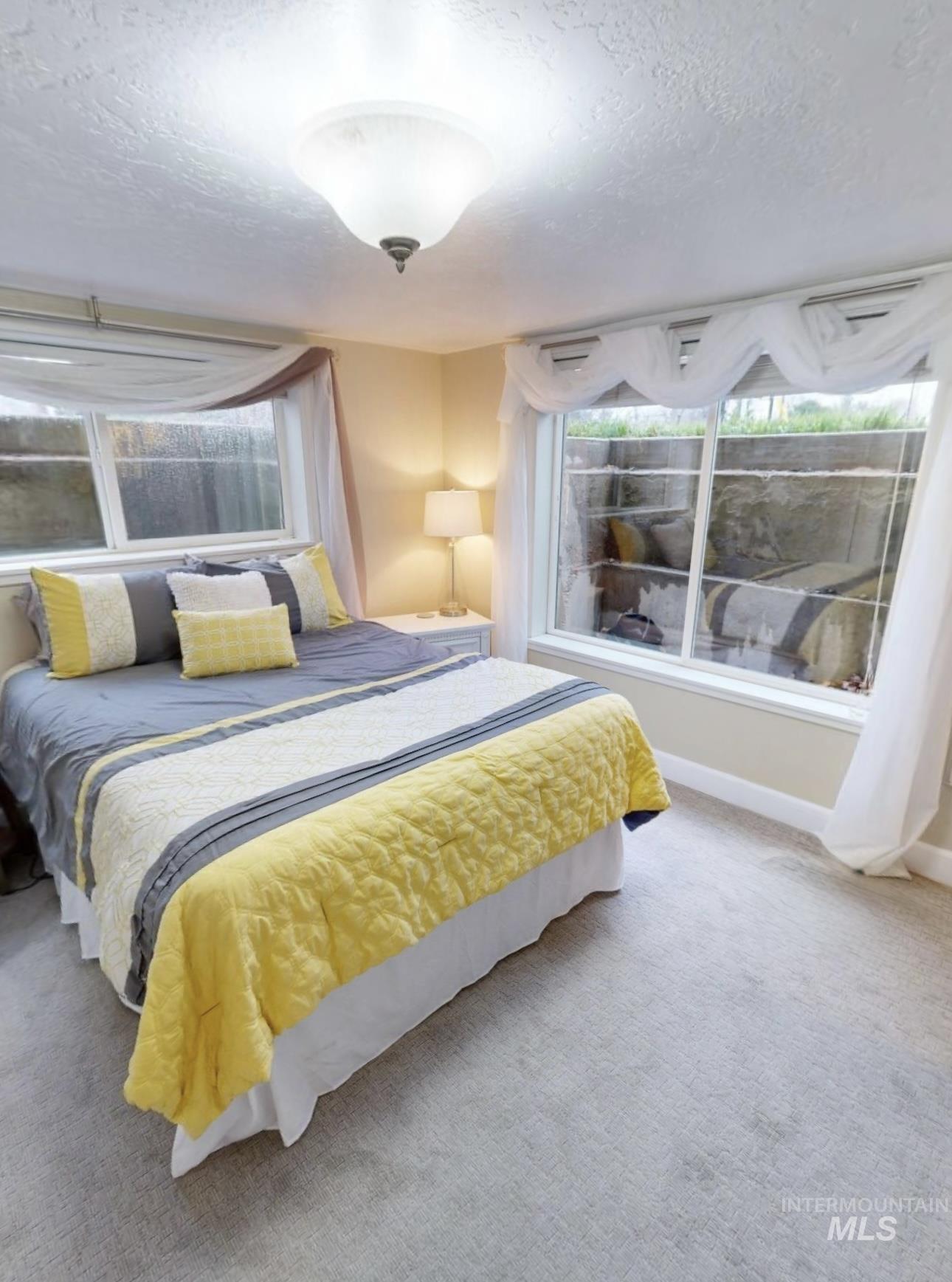 Carpeted bedroom with a textured ceiling