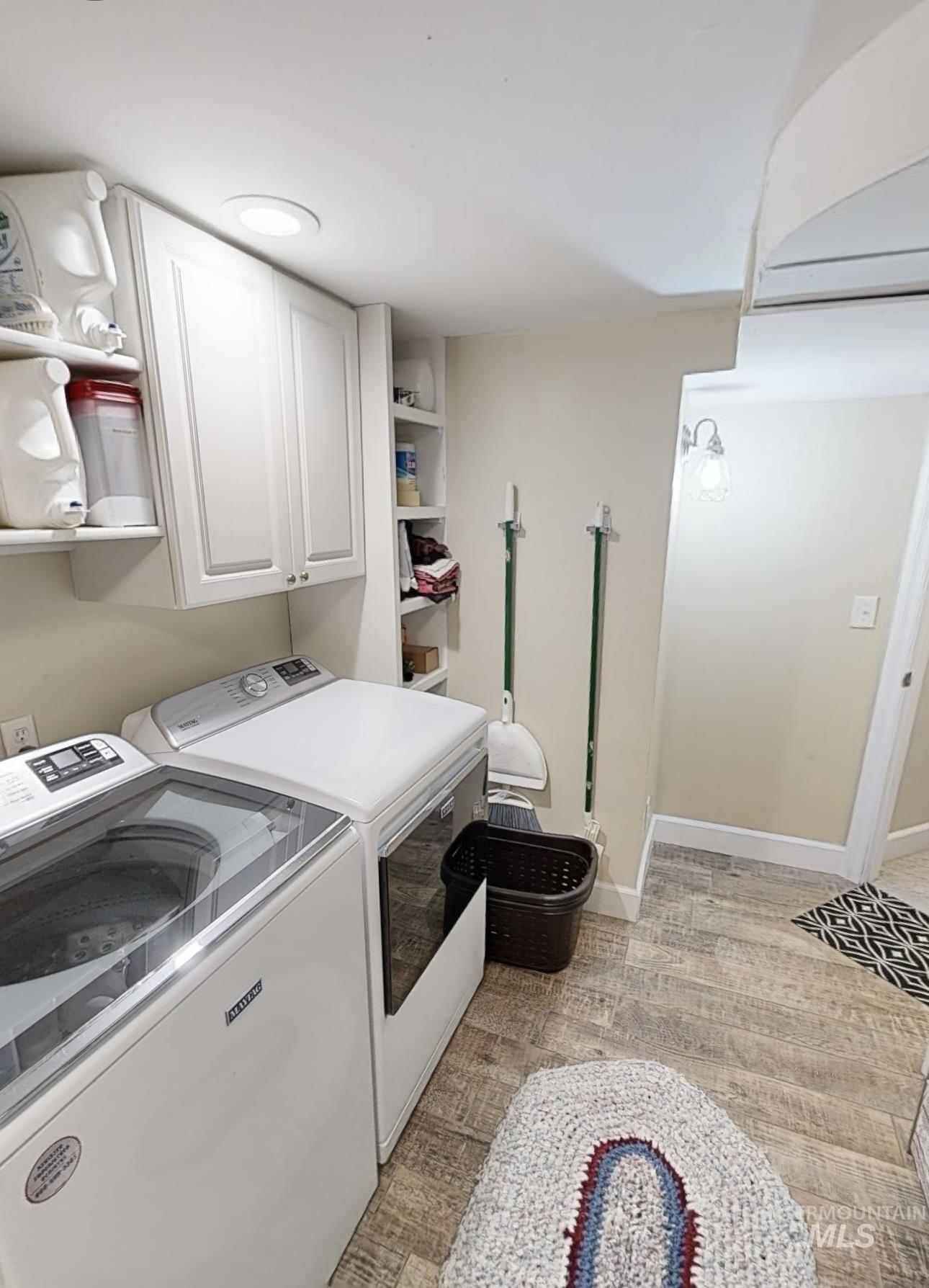 Laundry area featuring separate washer and dryer and baseboards