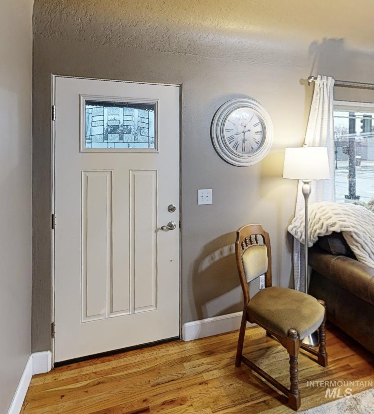 Foyer with light wood-type flooring and baseboards