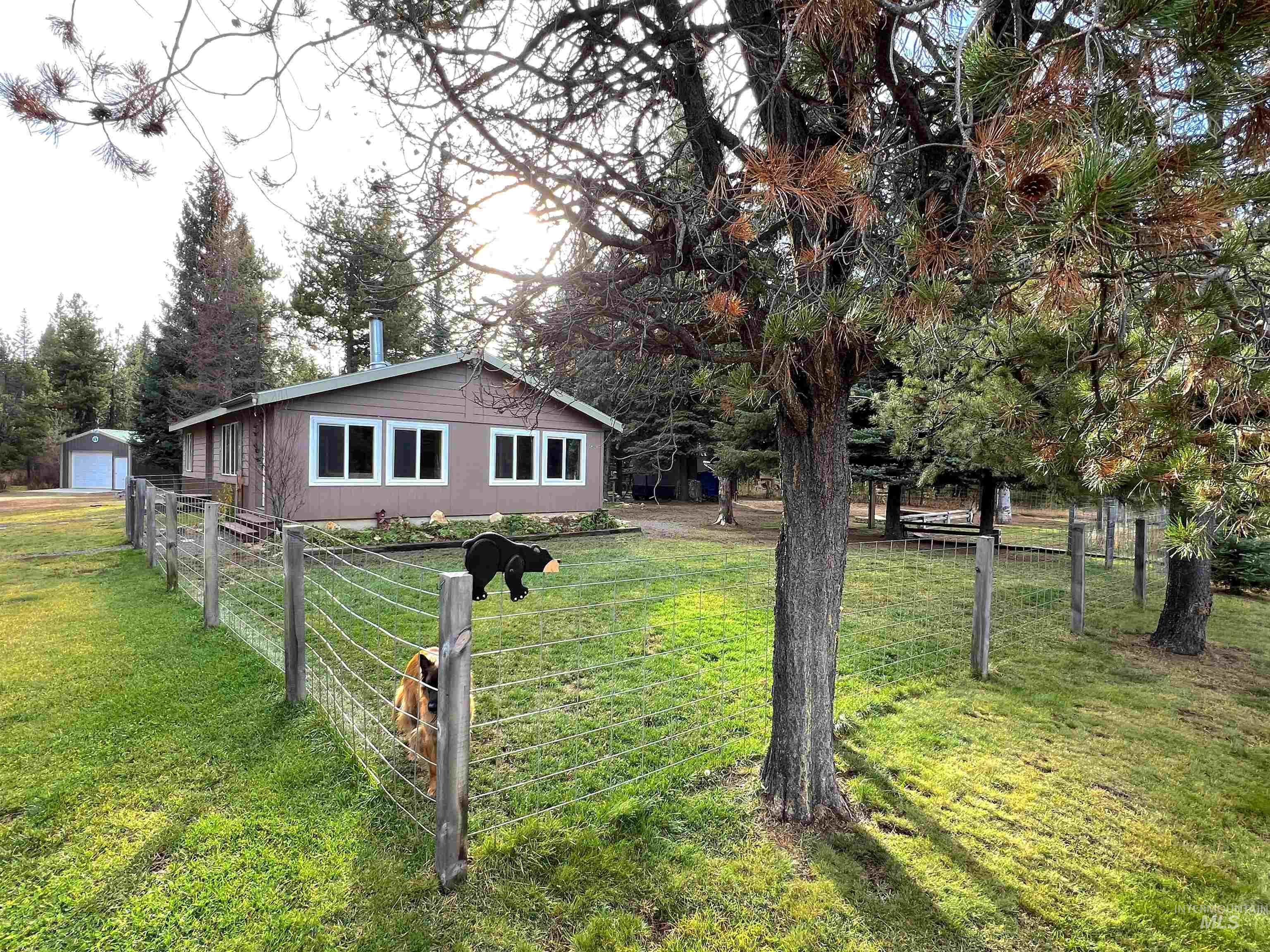 View of front of property featuring a garage and an outbuilding
