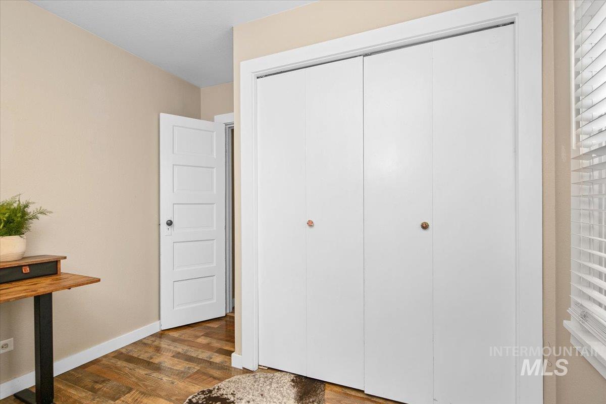 Bedroom featuring dark wood-type flooring and a closet