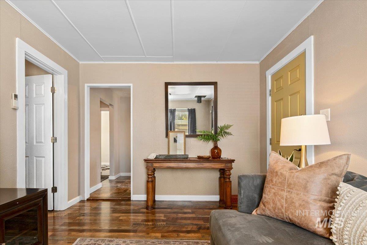 Living area featuring dark wood-type flooring and ornamental molding
