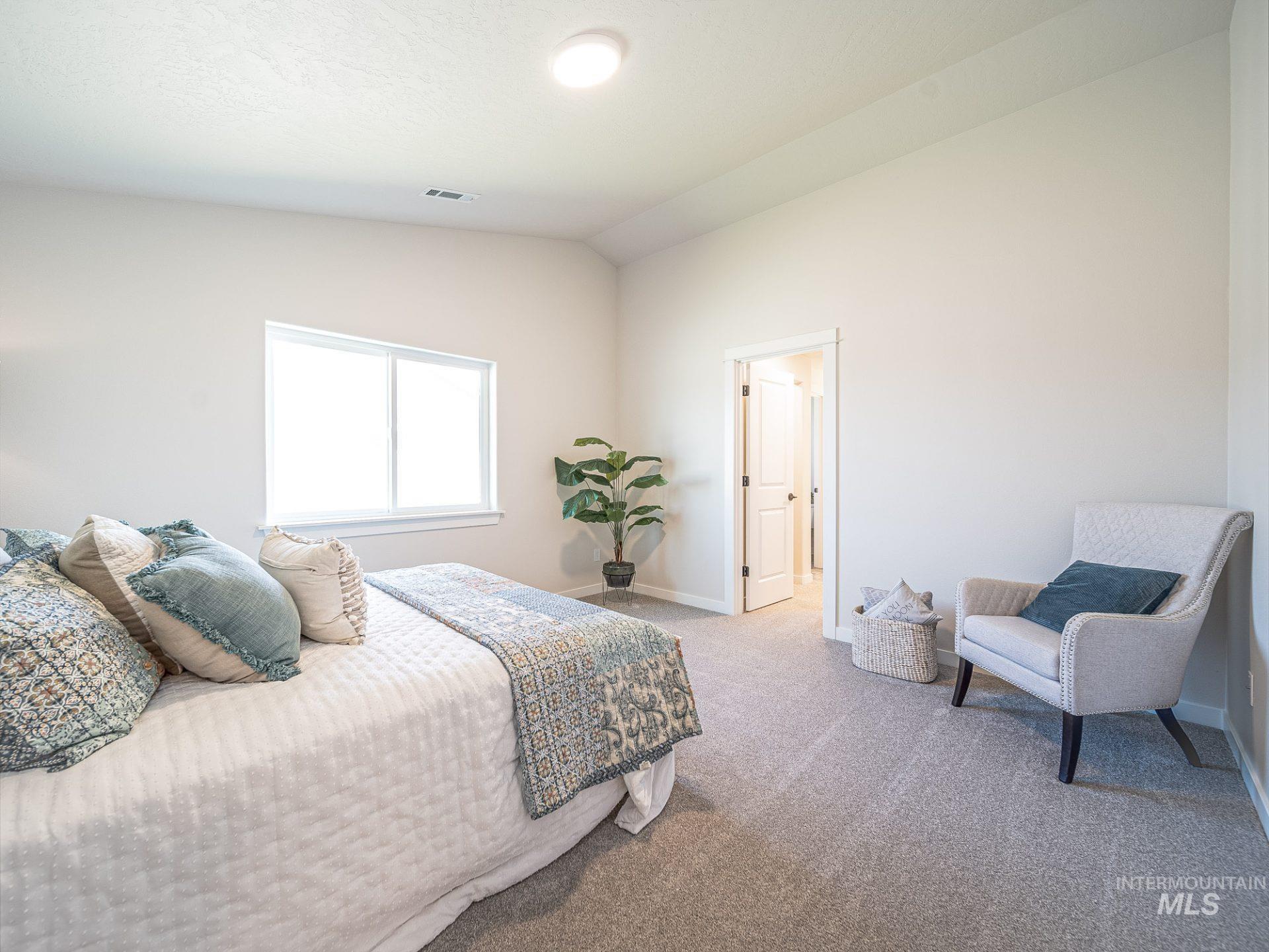 Bedroom featuring lofted ceiling and carpet flooring