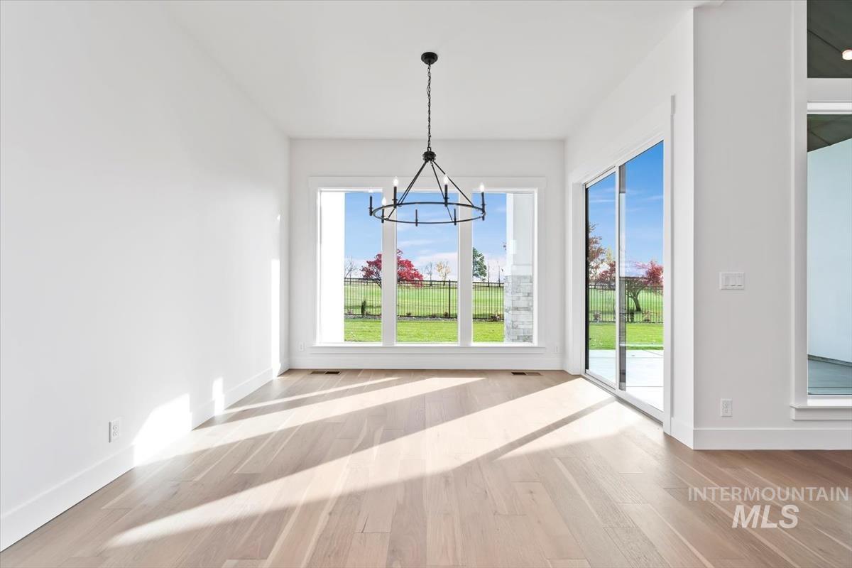 Unfurnished dining area with light wood-style floors and a chandelier