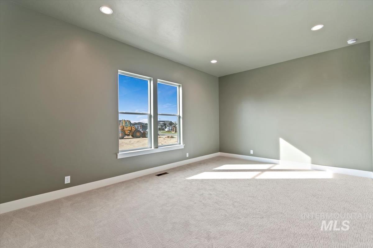 Carpeted empty room featuring baseboards and recessed lighting