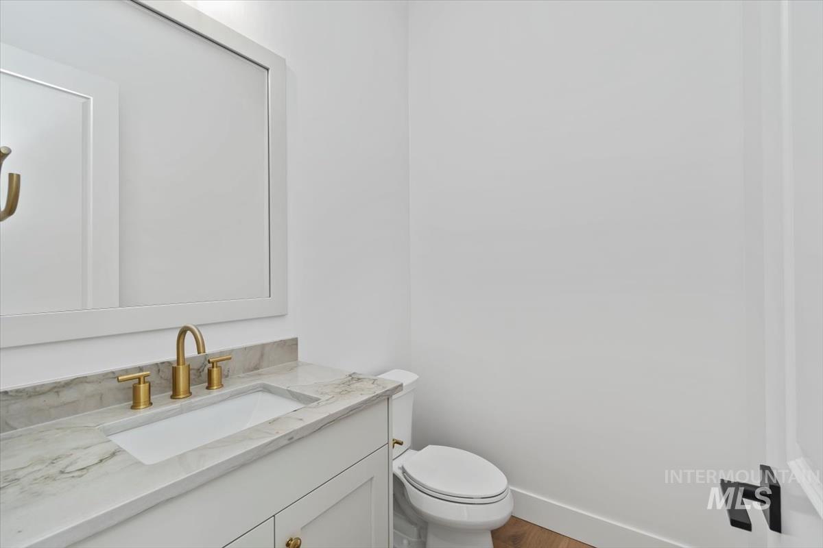 Half bath featuring vanity and wood finished floors