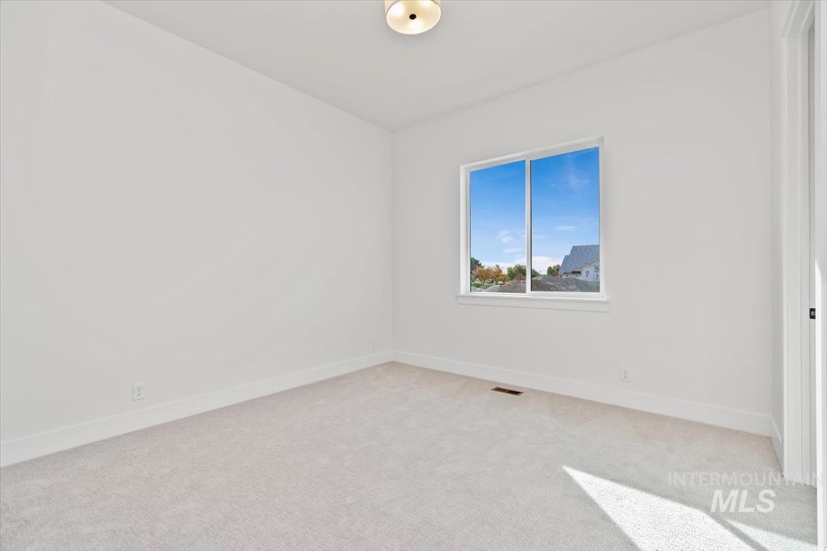 Carpeted empty room featuring baseboards