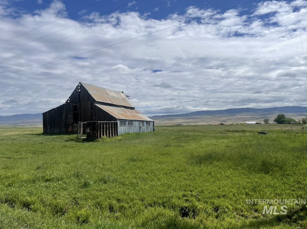 View of yard featuring a barn, an outbuilding, a mountain view, and a view of countryside