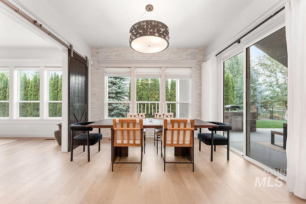 Dining space featuring a barn door and wood finished floors