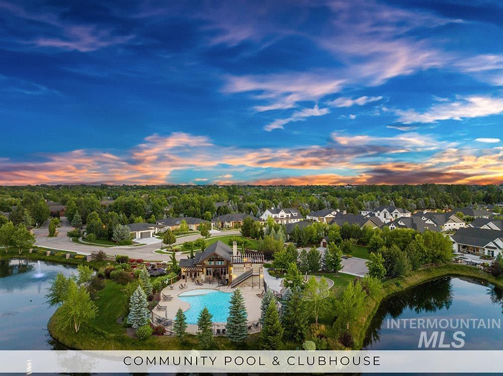 Aerial view at dusk of a water view and view of pool