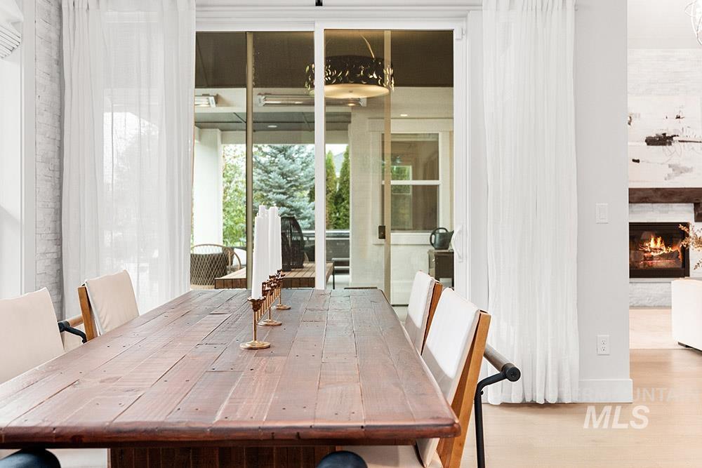 Dining area with wood finished floors and a lit fireplace