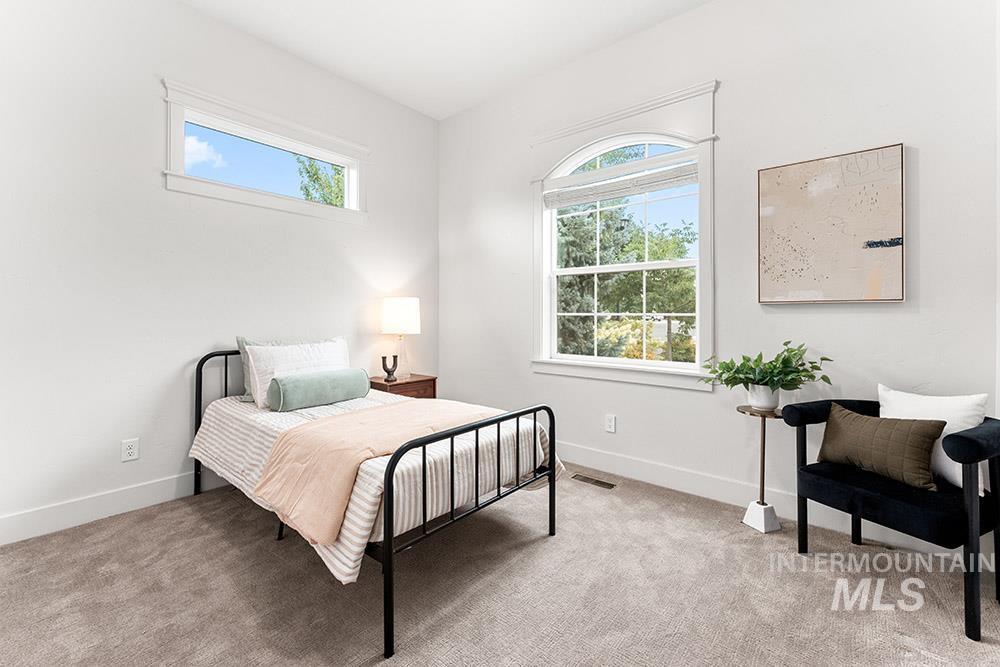 Bedroom featuring light colored carpet and baseboards