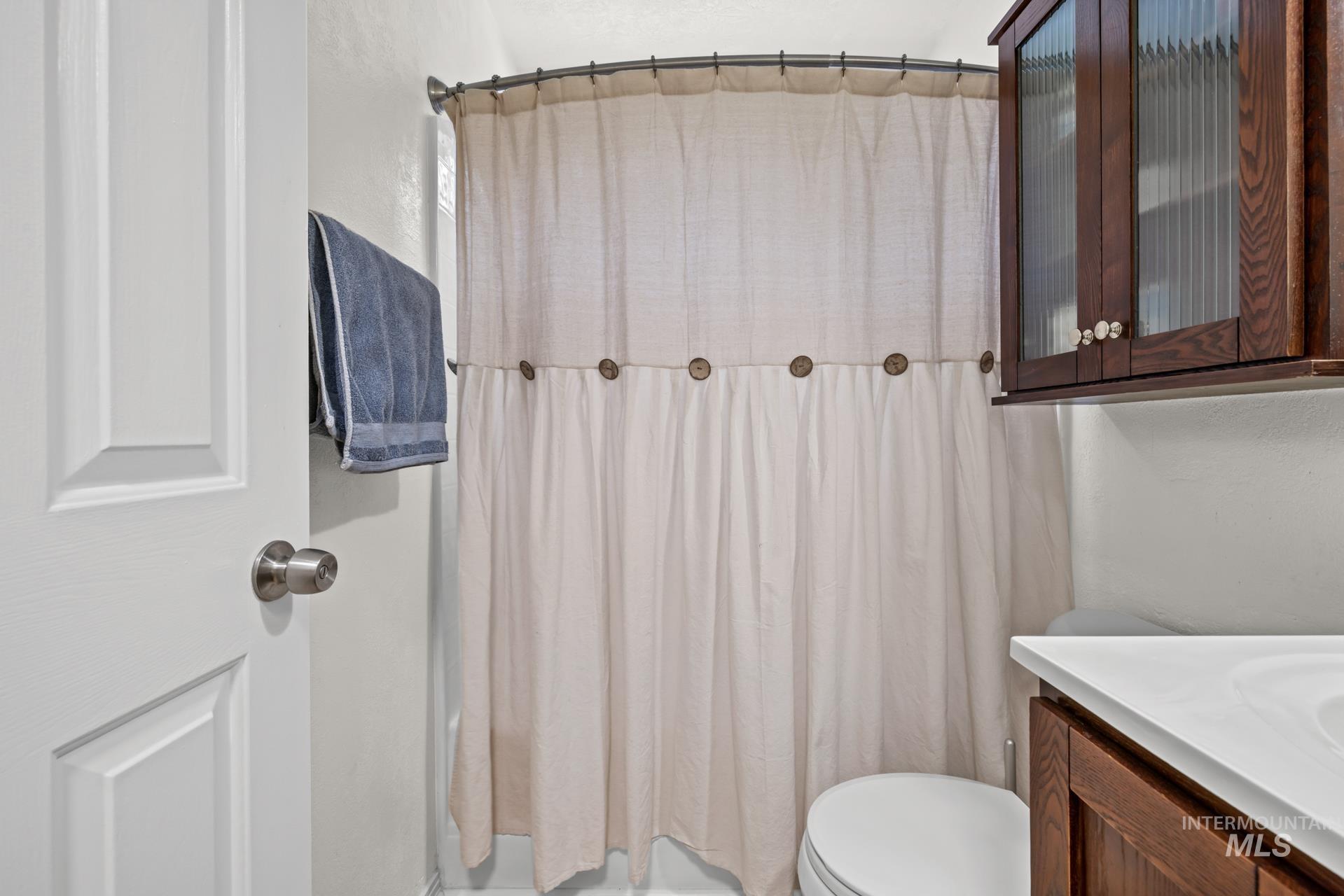 Bathroom with a shower with curtain and vanity