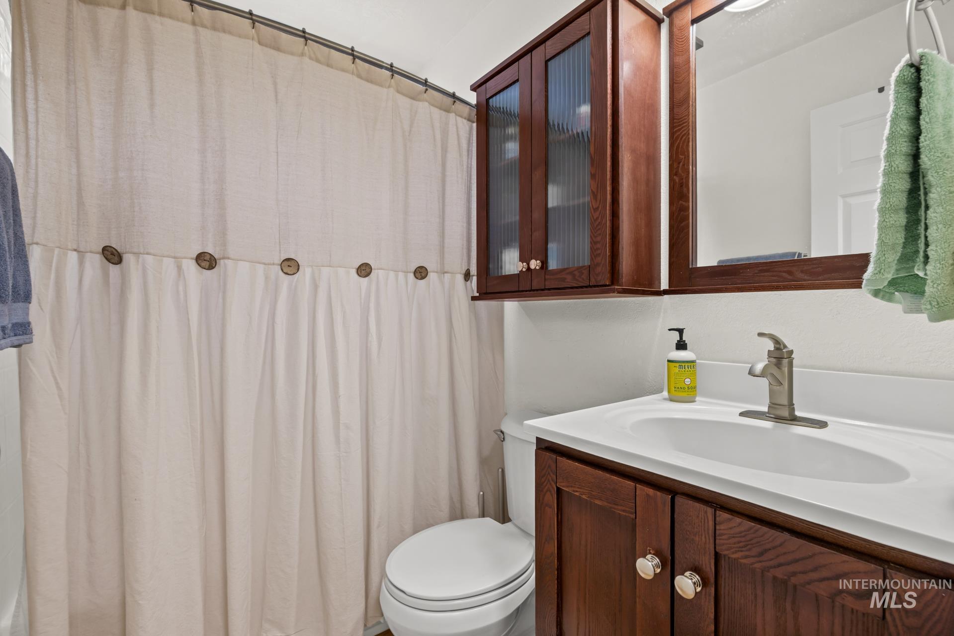 Bathroom with a shower with shower curtain and vanity