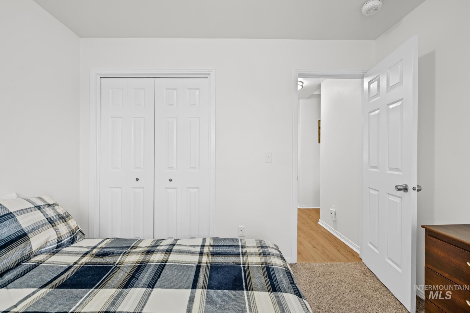 Carpeted bedroom featuring a closet and baseboards