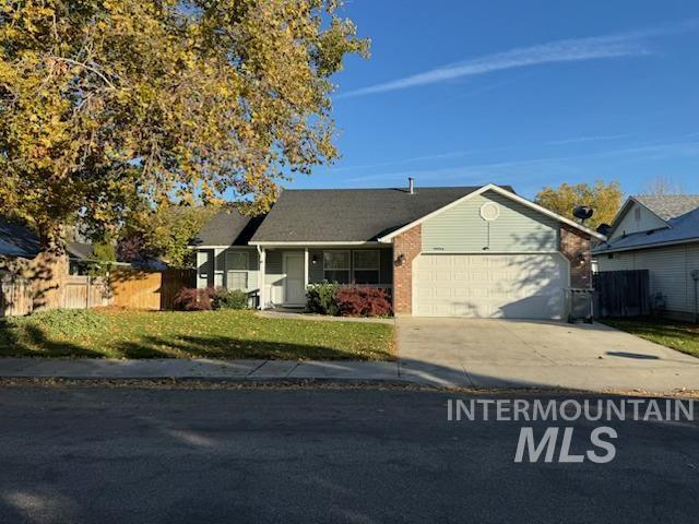 View of front of property featuring driveway, covered porch, an attached garage, and brick siding