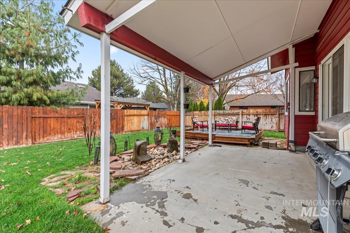 Fenced backyard featuring a patio, a grill, and a deck
